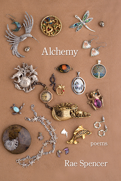 Photo of the front cover of Alchemy, which features trinkets and jewelry (many passed down from my mother) arranged on a cloth background. Each broach, bracelet, pendant, earring, and trinket illustrates a theme or topic from the poetry. Featured in the center, a Noah's ark pin and a globe-and-animals pin are connected by an antique miniature watch on a chain. Other items show mammals, birds, insects, fish, reptiles, amphibians, plants, and a fossilized seashell. Text on the cover reads "Alchemy, poems, Rae Spencer".